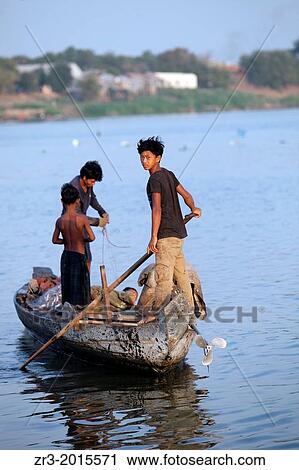 Stock Image - Young fisherman work the Mekong River early in the morning outside of Phnom Penh, Cambodia.. Fotosearch