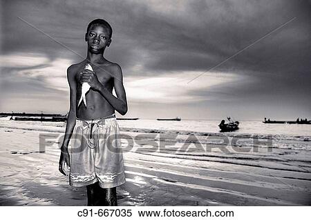 Stock Photography - Young fishermen in the evening. Gambia. Fotosearch