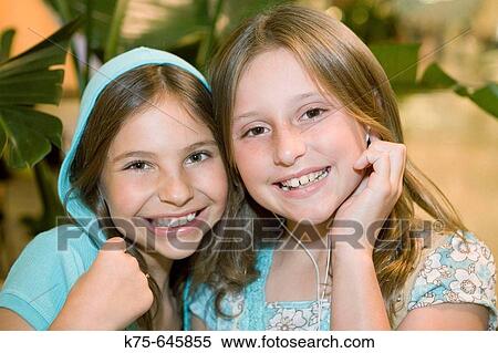 young friends hugging and listening to earbuds View Large Photo Image Stock Photography - young friends hugging and listening to earbuds. Fotosearch