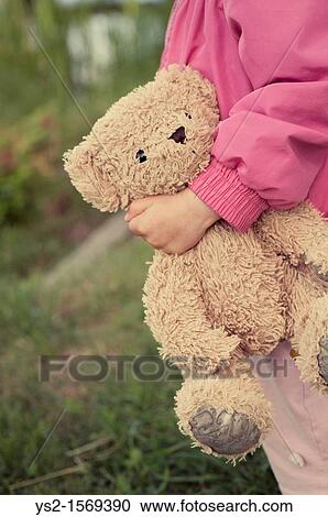 Stock Image - Young girl 1-2 years holding a Teddy Bear. Fotosearch