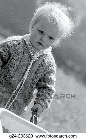 Young girl (1 yr. ) in meadow with long necklace View Large Photo Image Stock Image - Young girl (1 yr. ) in meadow with long necklace. Fotosearch