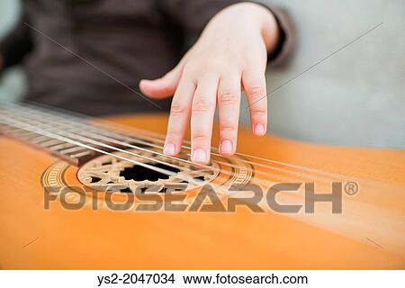 Young girl, 4 years old, playing on an acoustic guitar. View Large Photo Image Picture - Young girl, 4 years old, playing on an acoustic guitar.. Fotosearch