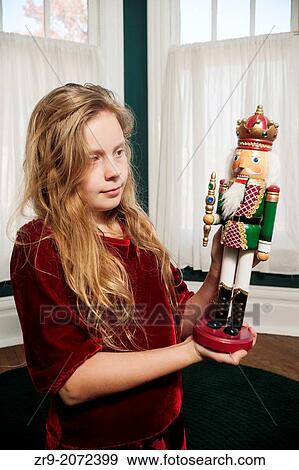 Stock Photo - Young girl admires Christmas nutcracker at home, Indiana, USA.. Fotosearch