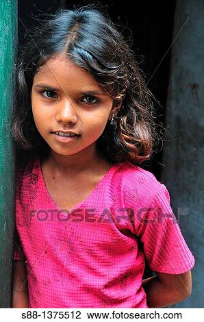 Stock Image - Young girl at narrow street of the old town near the Ganges River. Fotosearch