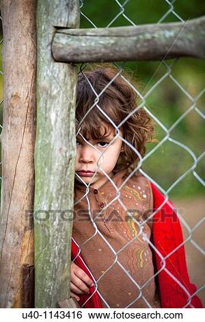 Stock Photograph - Young girl behind fence. Fotosearch