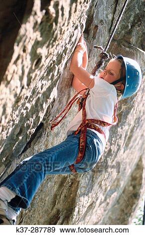 Young girl climbing rock face at rock climbing school View Large Photo Image Stock Photo - Young girl climbing rock face at rock climbing school. Fotosearch