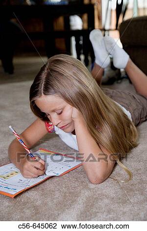 Stock Image - young girl does her home work.. Fotosearch