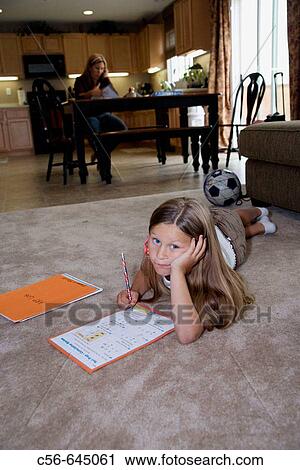 young girl does her homework, mother in background. View Large Photo Image Stock Image - young girl does her homework, mother in background.. Fotosearch