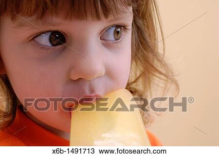 Young girl eating a frozen ice pop View Large Photo Image Stock Image - Young girl eating a frozen ice pop. Fotosearch