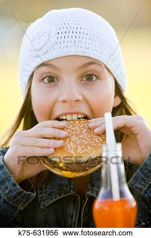 Young girl eating cheeseburger. View Large Photo Image Stock Photograph - Young girl eating cheeseburger.. Fotosearch