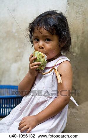 Stock Image - Young girl eating raw cacao. Fotosearch