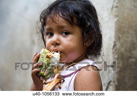 Stock Image - Young girl eating raw cacao. Fotosearch