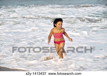 Stock Photo - Young girl enjoys the ocean water, Cape Cod, MA, USA. Fotosearch