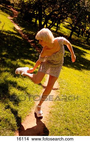 Picture - Young girl fixing her shoe. Fotosearch