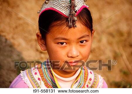 Stock Image - Young girl from Yi Minority in traditional dress and bonnet. Yuangyang, Yunnan province. China. Fotosearch