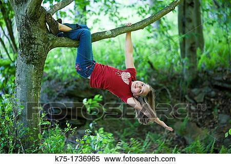 Young girl hanging from tree branch View Large Photo Image Stock Photography - Young girl hanging from tree branch. Fotosearch