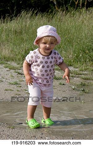 Young girl having fun in a puddle on a warm summer morning MR View Large Photo Image Stock Image - Young girl having fun in a puddle on a warm summer morning MR. Fotosearch