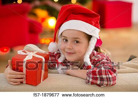 Young girl holding a gift at Christmas time View Large Photo Image Stock Photo - Young girl holding a gift at Christmas time. Fotosearch