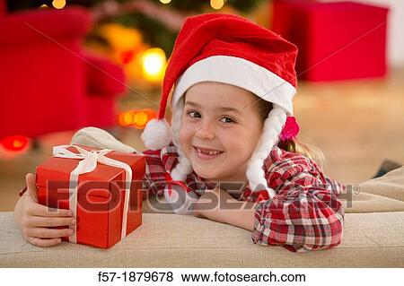 Young girl holding a gift at Christmas time View Large Photo Image Stock Photo - Young girl holding a gift at Christmas time. Fotosearch
