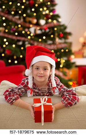 Young girl holding a gift at Christmas time View Large Photo Image Stock Photography - Young girl holding a gift at Christmas time. Fotosearch