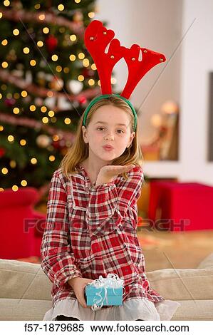 Young girl holding a gift at Christmas time View Large Photo Image Stock Photography - Young girl holding a gift at Christmas time. Fotosearch