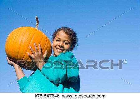 Young girl holding big pumpkin View Large Photo Image Stock Photograph - Young girl holding big pumpkin. Fotosearch