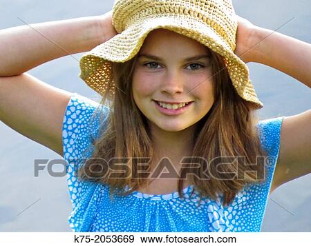 Young girl holding her straw hat View Large Photo Image Stock Photo - Young girl holding her straw hat. Fotosearch