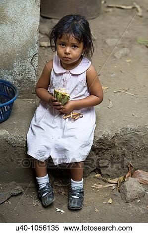 Stock Photography - Young girl holding raw cacao pod. Fotosearch
