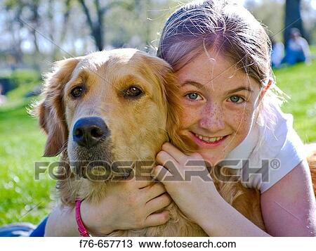 Young girl hugging her one year old golden retriever in central park, USA View Large Photo Image Stock Image - Young girl hugging her one year old golden retriever in central park, USA. Fotosearch