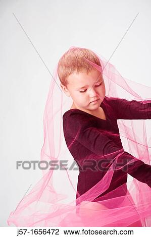 Stock Image - Young girl in a black leotard with pediatric cancer leukimia playing with fabric in the studio. Fotosearch