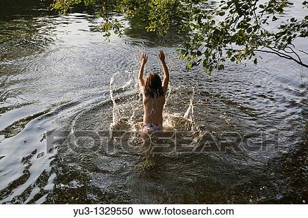 Young girl in a river splashing water View Large Photo Image Stock Image - Young girl in a river splashing water. Fotosearch