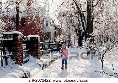 Young girl in pink coat walks along a snowy sidewalk in her neighborhood in winter. View Large Photo Image Stock Image - Young girl in pink coat walks along a snowy sidewalk in her neighborhood in winter.. Fotosearch