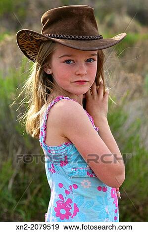Young girl in the country wearing cowboy hat View Large Photo Image Stock Photo - Young girl in the country wearing cowboy hat. Fotosearch