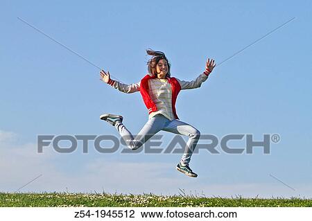 Stock Image - Young girl jumping in air, Spain.. Fotosearch