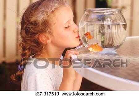Young girl kissing goldfish in bowl View Large Photo Image Stock Photo - Young girl kissing goldfish in bowl. Fotosearch