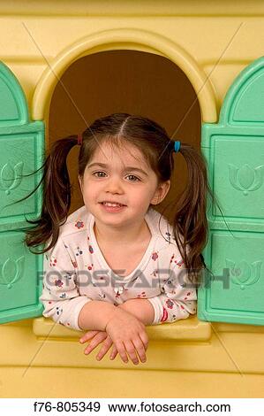 Stock Photo - Young girl, leaning out window of play house. Fotosearch