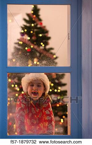 Young girl looking out of the window waiting for Santa to arrive View Large Photo Image Stock Image - Young girl looking out of the window waiting for Santa to arrive. Fotosearch