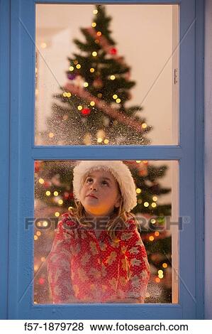 Young girl looking out of the window waiting for Santa to arrive View Large Photo Image Stock Photo - Young girl looking out of the window waiting for Santa to arrive. Fotosearch