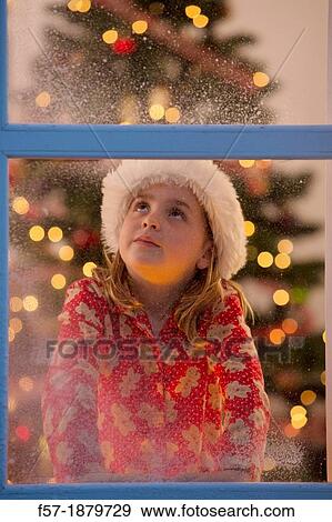Young girl looking out of the window waiting for Santa to arrive View Large Photo Image Stock Photo - Young girl looking out of the window waiting for Santa to arrive. Fotosearch