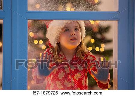 Young girl looking out of the window waiting for Santa to arrive View Large Photo Image Stock Photograph - Young girl looking out of the window waiting for Santa to arrive. Fotosearch