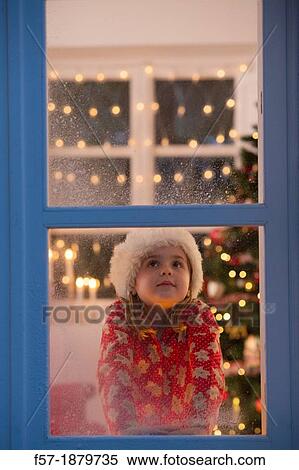 Young girl looking out of the window waiting for Santa to arrive View Large Photo Image Stock Photography - Young girl looking out of the window waiting for Santa to arrive. Fotosearch