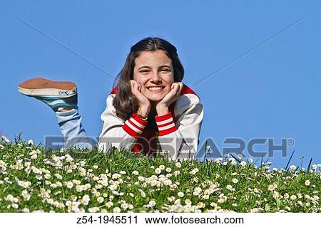 Young girl lying down grass, Spain. View Large Photo Image Stock Image - Young girl lying down grass, Spain.. Fotosearch