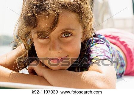 Young girl lying in the sun. View Large Photo Image Stock Photo - Young girl lying in the sun.. Fotosearch