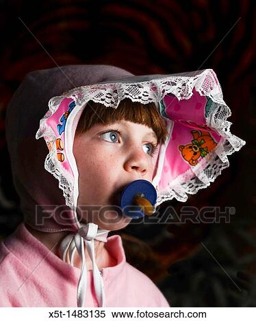 Stock Photography - Young girl of 6 dressed up as a baby with pacifier in her mouth. Fotosearch