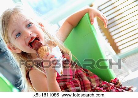 Young girl of three eats chocolate ice cream View Large Photo Image Stock Photograph - Young girl of three eats chocolate ice cream. Fotosearch