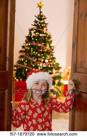 Young girl opening the living room doors at Christmas time View Large Photo Image Stock Image - Young girl opening the living room doors at Christmas time. Fotosearch