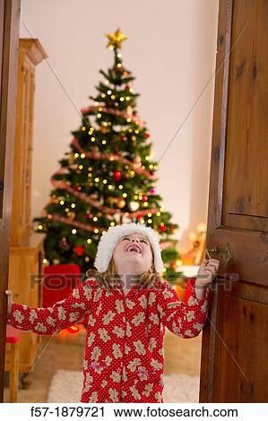 Young girl opening the living room doors at Christmas time View Large Photo Image Stock Image - Young girl opening the living room doors at Christmas time. Fotosearch