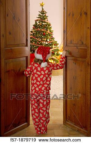 Young girl opening the living room doors at Christmas time View Large Photo Image Stock Photo - Young girl opening the living room doors at Christmas time. Fotosearch