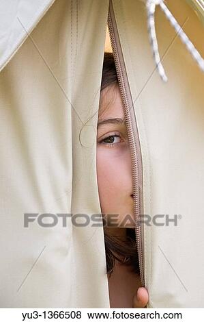 Young girl peeping through opening in a canvas tent View Large Photo Image Stock Photo - Young girl peeping through opening in a canvas tent. Fotosearch