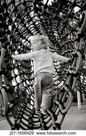 Young girl playing in a rope net playground in Zurich, Switzerland View Large Photo Image Stock Photo - Young girl playing in a rope net playground in Zurich, Switzerland. Fotosearch